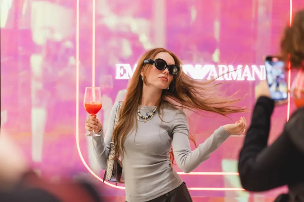 Frau mit Sonnenbrille posiert stilvoll mit Getränk