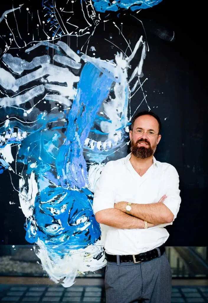 Mann vor abstraktem Gemälde in Blau und Weiß