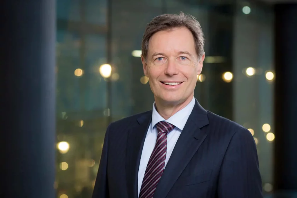 Mann im Anzug mit Krawatte vor unscharfem Hintergrund