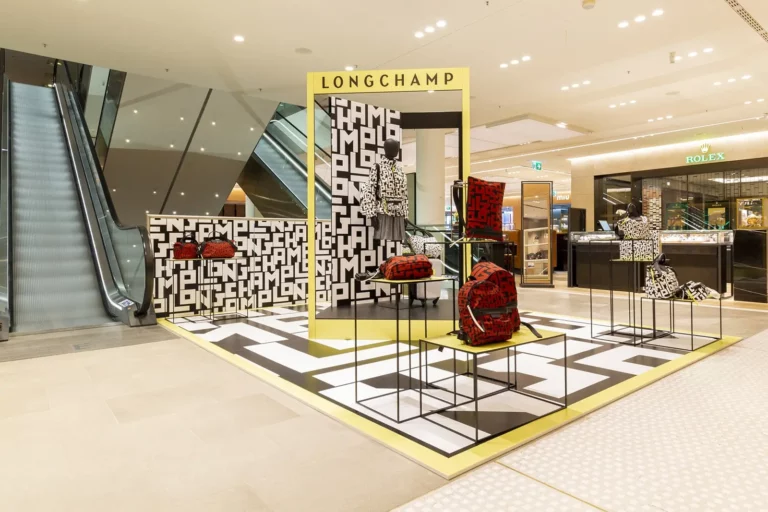 Longchamp-Display mit handgefertigten Taschen im modernen Kaufhaus