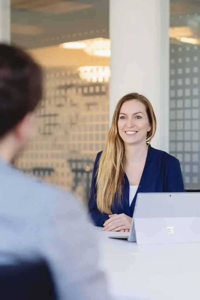 Lächelnde Frau in einem Geschäftstreffen mit Laptop