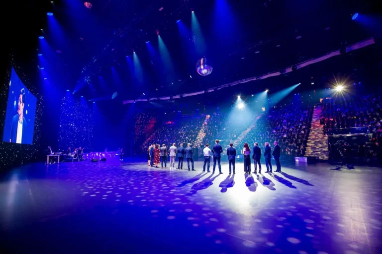 Menschenmenge auf einer beleuchteten Bühne bei einer Veranstaltung