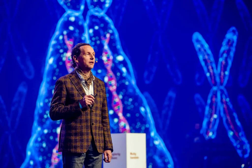 Mann vor digitalem Chromosomenhintergrund auf einer Bühne