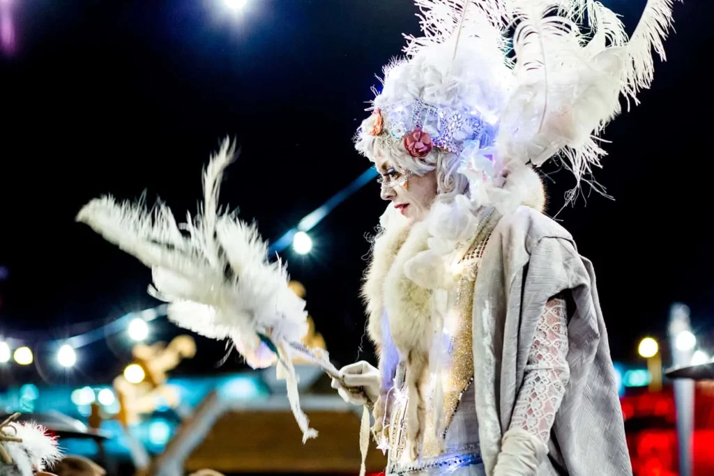 Karnevalskostüm mit weißen Federn und leuchtenden Akzenten