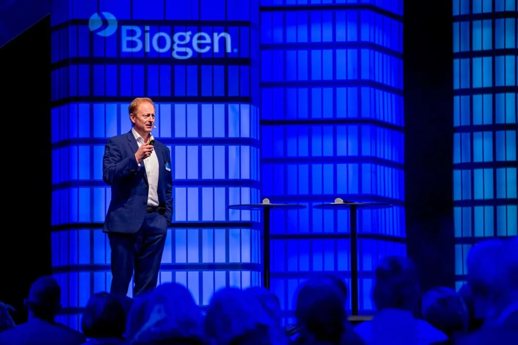 Redner auf einer Biogen-Konferenzbühne in blauem Anzug
