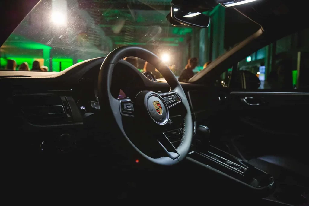 Lenkrad eines Porsche bei einer nächtlichen Veranstaltung