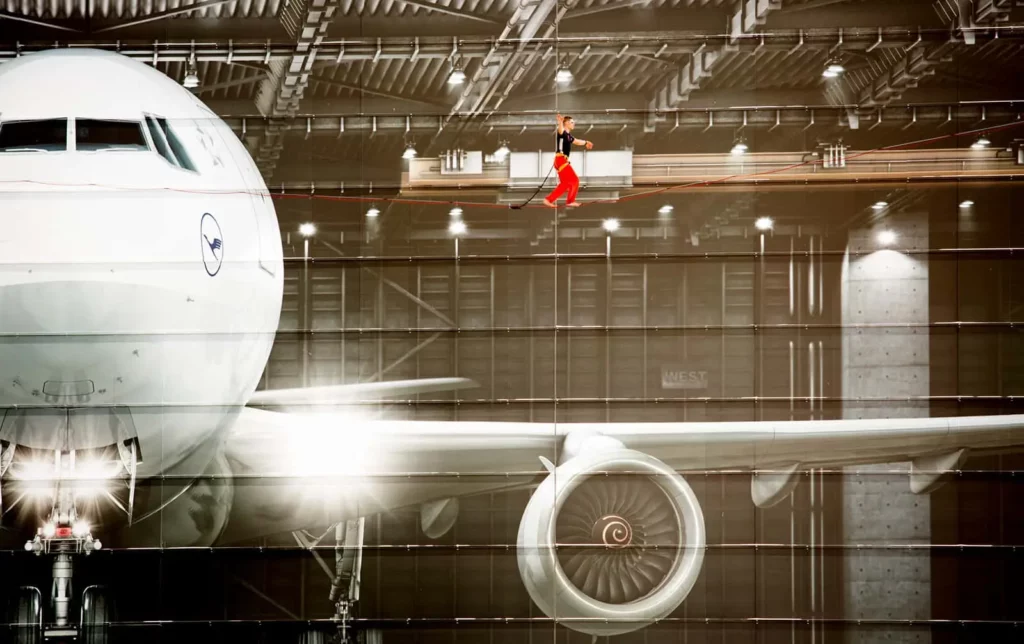 Flugzeug in Hangar mit Slackline-Akrobatik-Performance