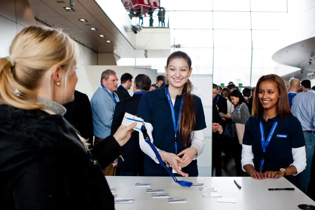Empfangsdame begrüßt Teilnehmer bei einer Konferenz oder Veranstaltung