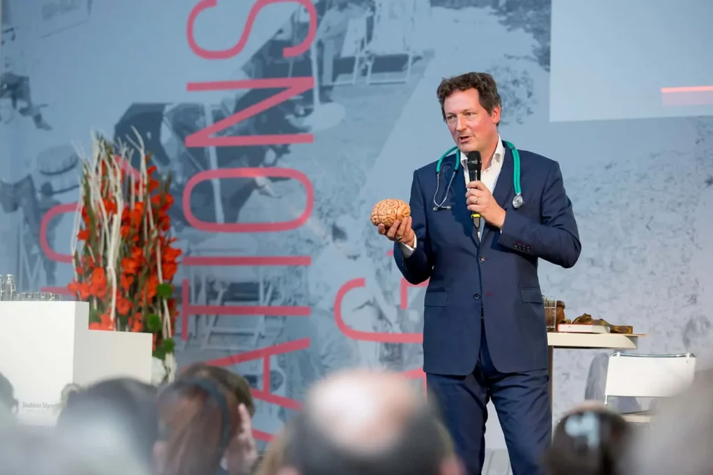 Arzt hält Gehirnmodell als Vortragsstütze auf Konferenz