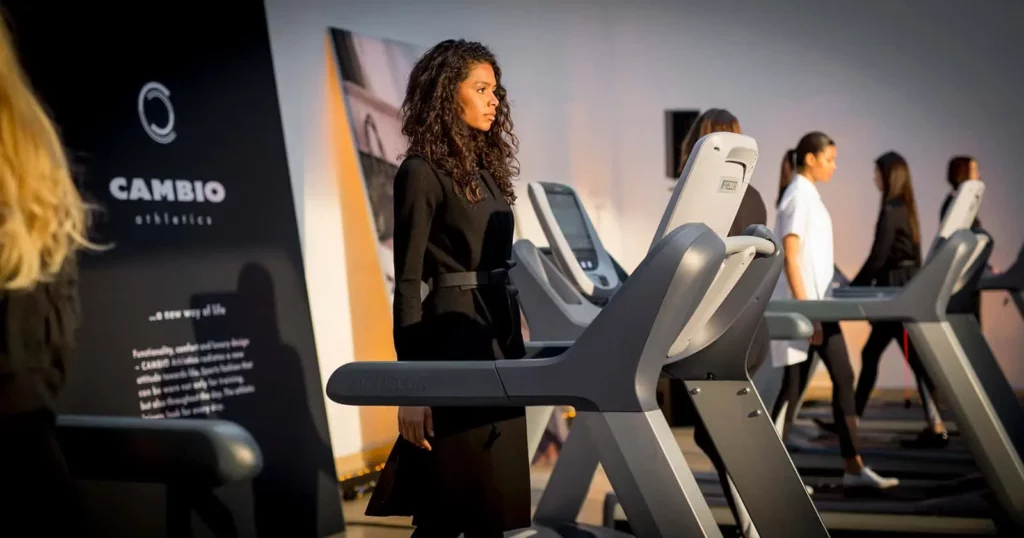 Frau auf Laufband, umgeben von moderner Fitnessausrüstung