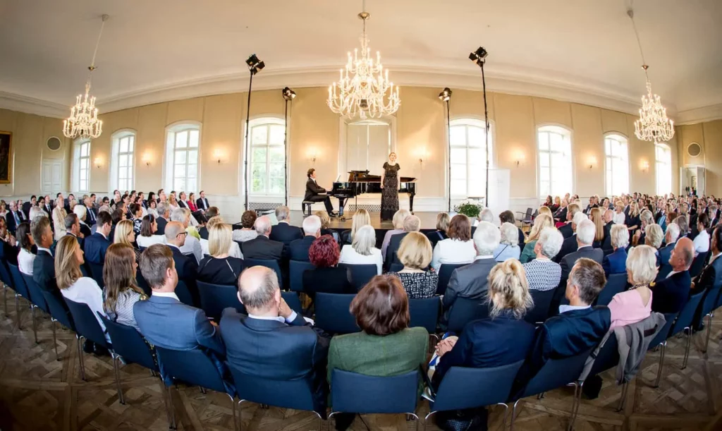 Konzert im Saal, Sängerin und Pianist mit Publikum