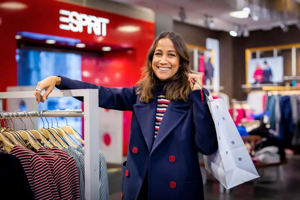 Frau beim Einkaufen in Esprit-Filiale mit Einkaufstasche