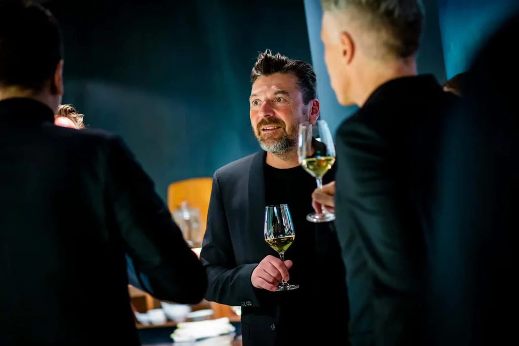 Mann in Anzug genießt Wein bei einer Veranstaltung