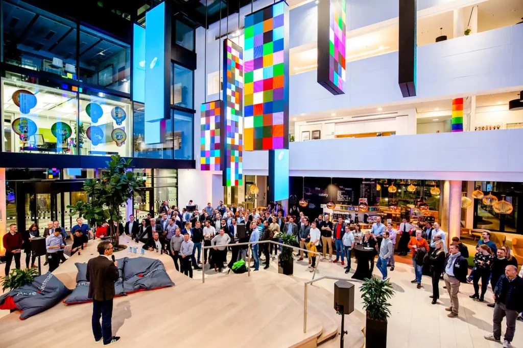 Großes Firmenevent in modernem Atrium mit bunten Installationen