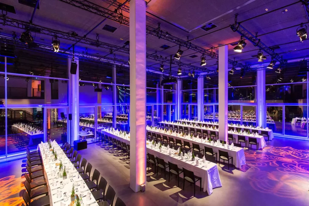 Modernes Veranstaltungslokal mit eleganter Beleuchtung und gedeckten Tischen