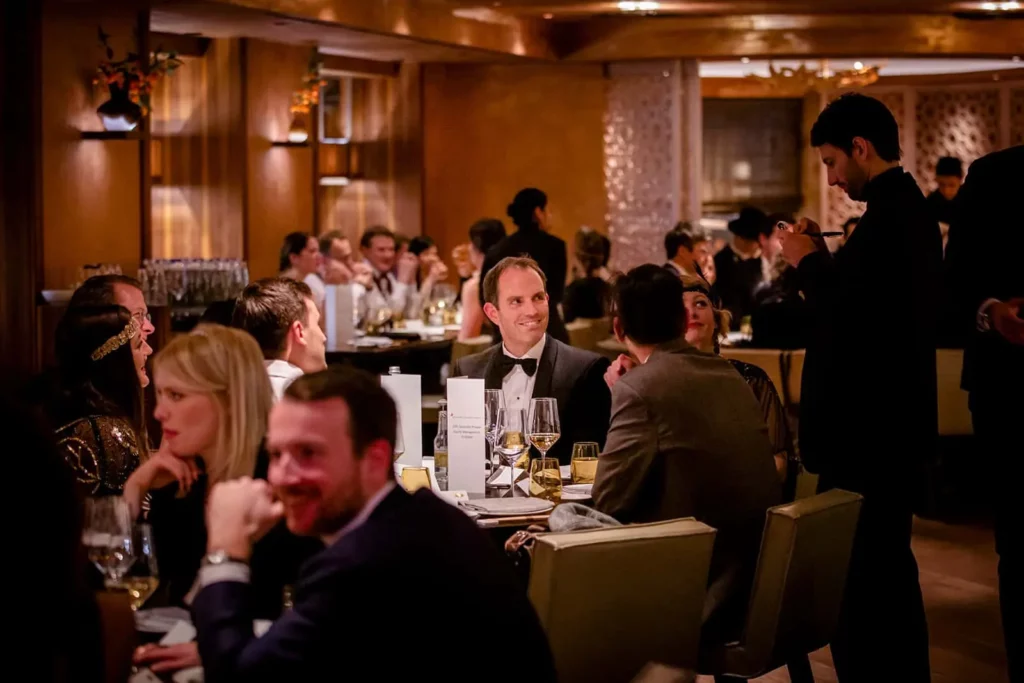 Elegantes Abendessen mit Gästen in festlicher Kleidung