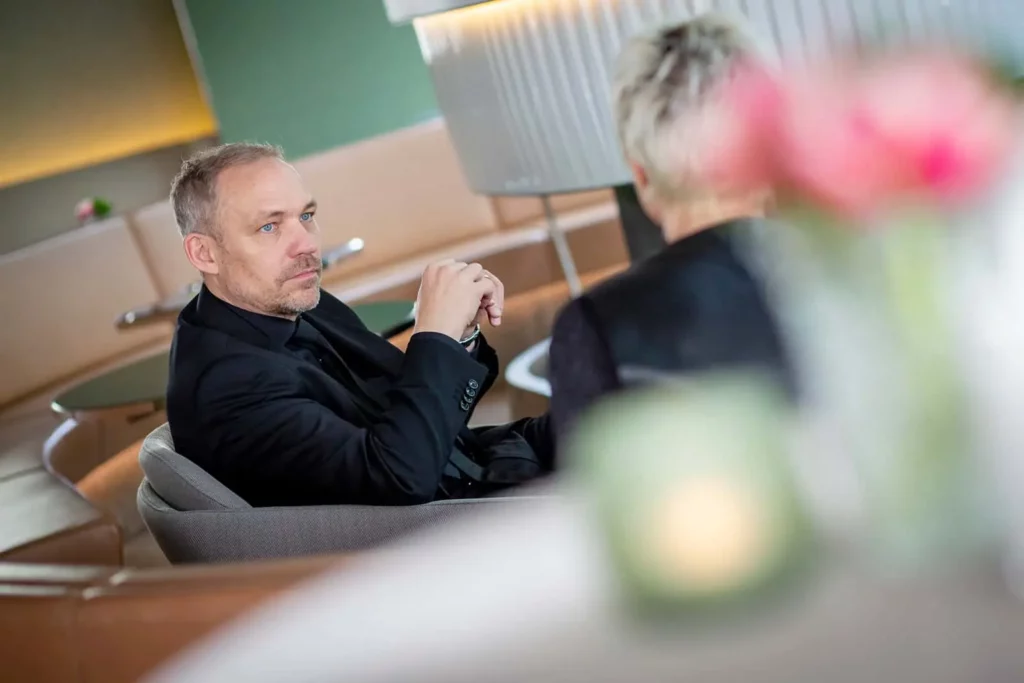 Zwei Personen im Gespräch in einem modernen Lounge-Bereich