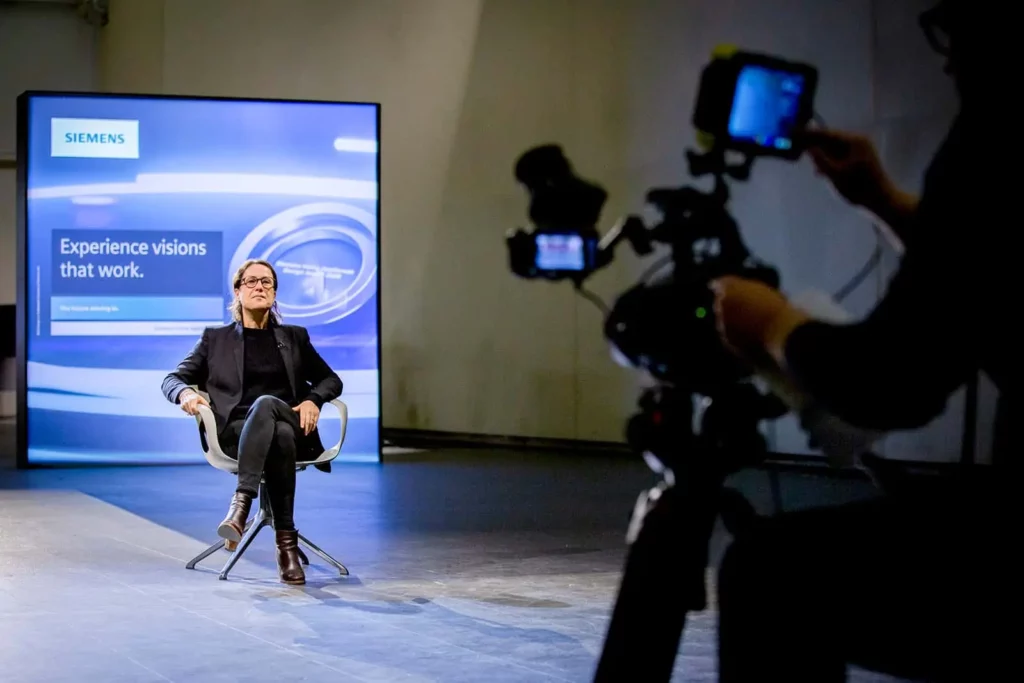 Person in modern Studio mit Siemens Display im Hintergrund