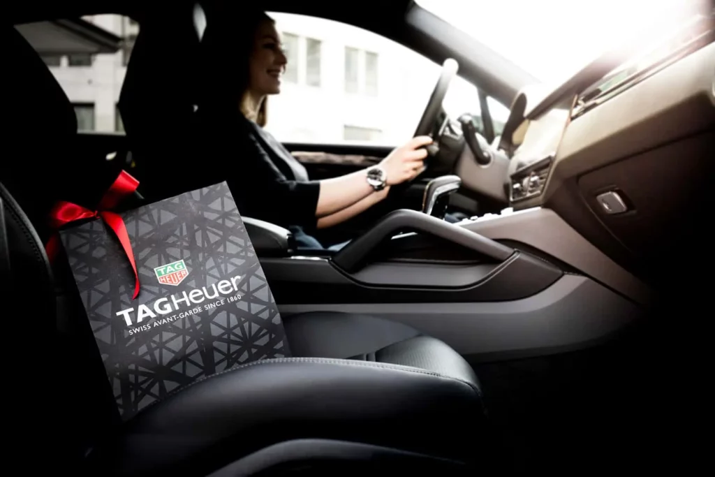 Person fährt Auto mit Tag Heuer Uhrengeschenk
