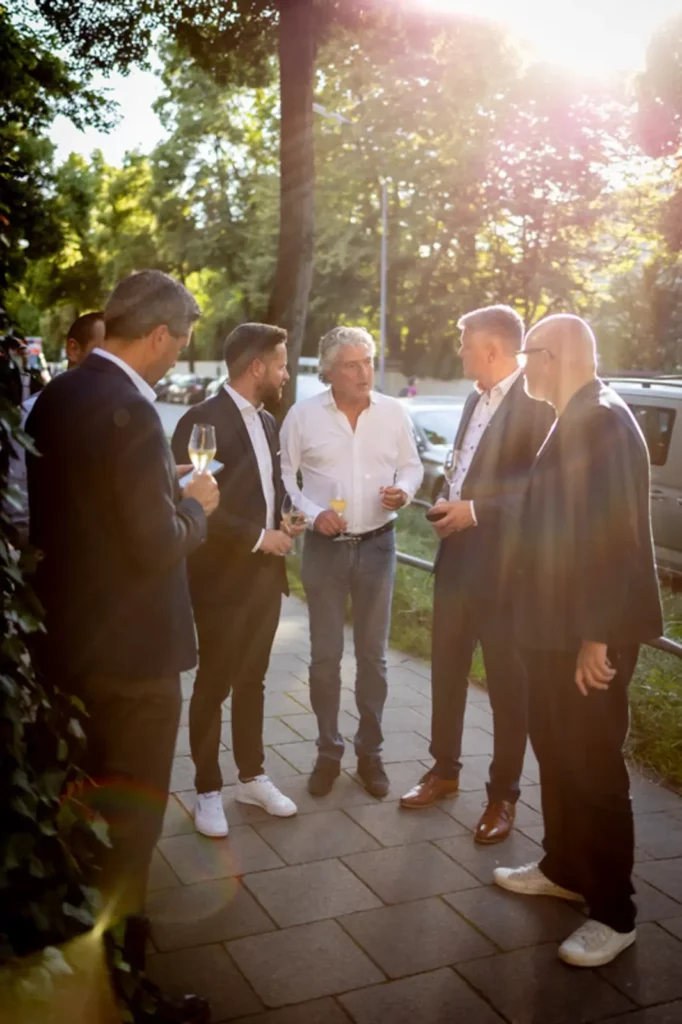 Gruppe von Männern in Anzügen bei einem Sonnenuntergang im Freien