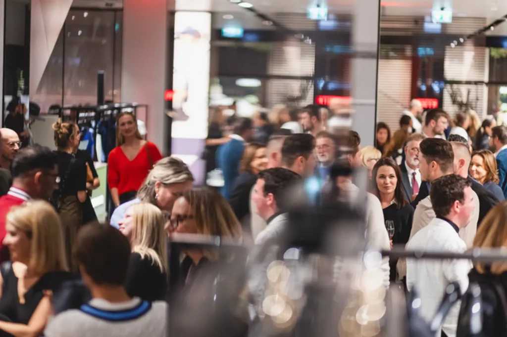 Voller Veranstaltungssaal mit Menschen in geschäftiger Atmosphäre