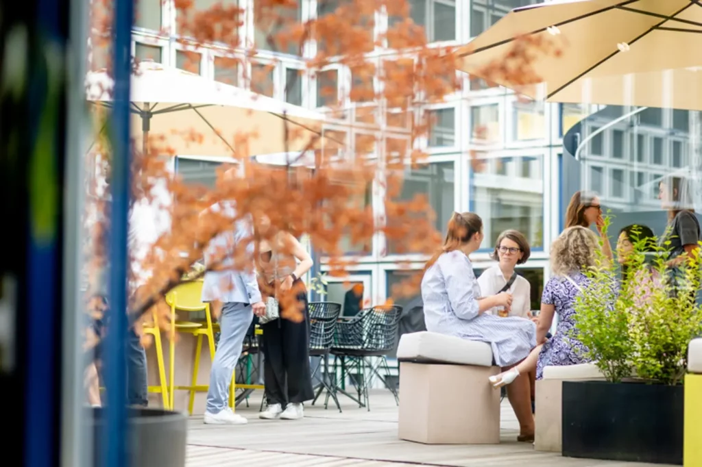 Gruppe von Menschen sitzt draußen in einem modernen Café