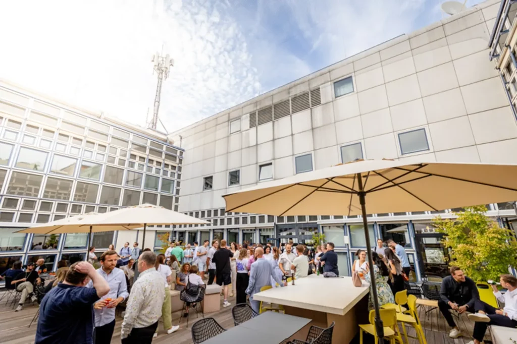 Menschenmenge auf moderner Außenterrasse bei Sonnenschein