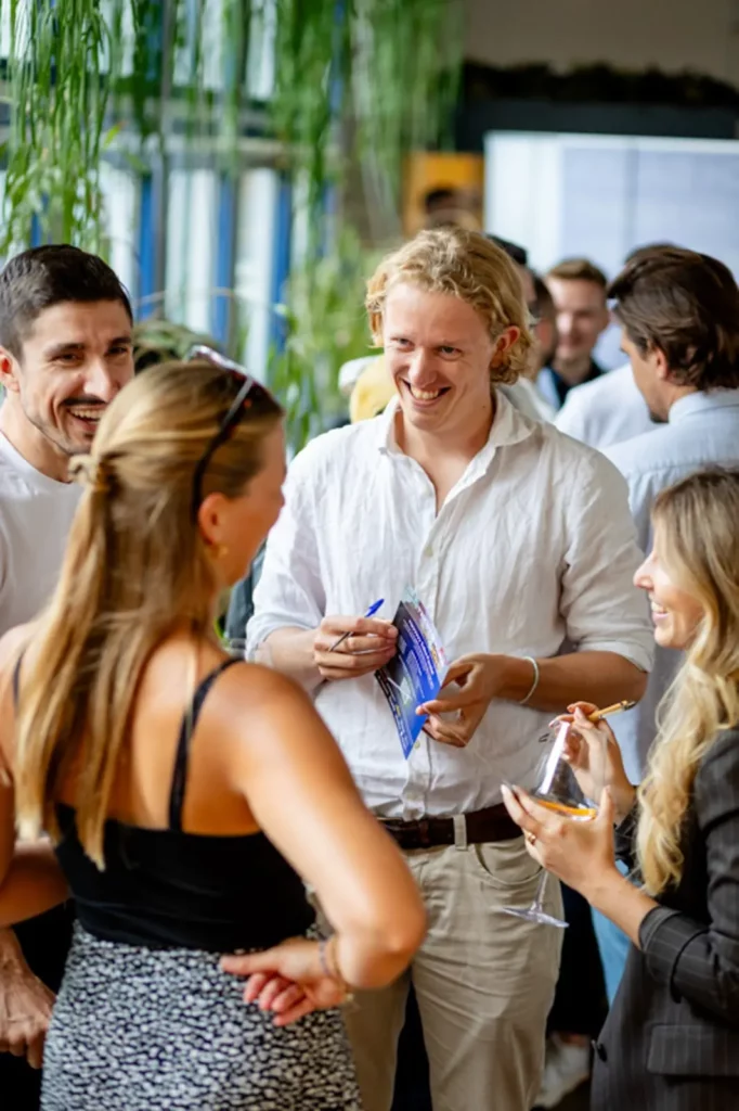 Lächelnde Gruppe von Menschen bei einer Networking-Veranstaltung in lockerer Atmosphäre