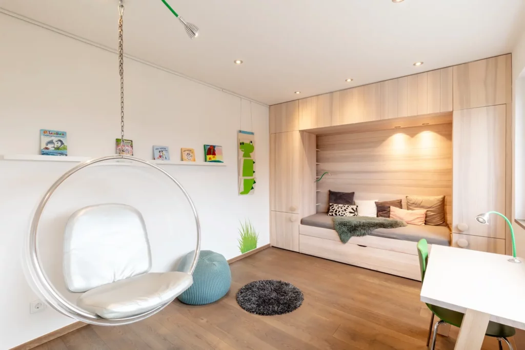 Modernes Kinderzimmer mit Schaukelstuhl und eingebautem Bett in Holzoptik