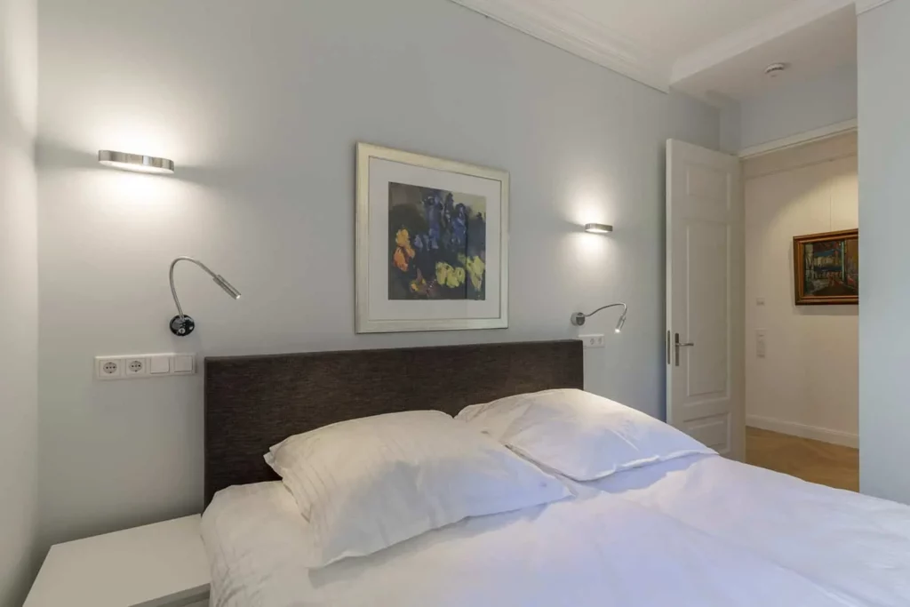 Gemütliches Schlafzimmer mit modernem Doppelbett und eleganter Wandkunst