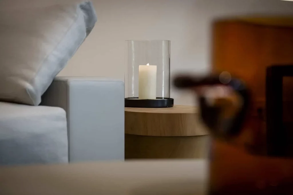 Weißes Sofa mit Kerze auf Holzbeistelltisch im modernen Wohnzimmer