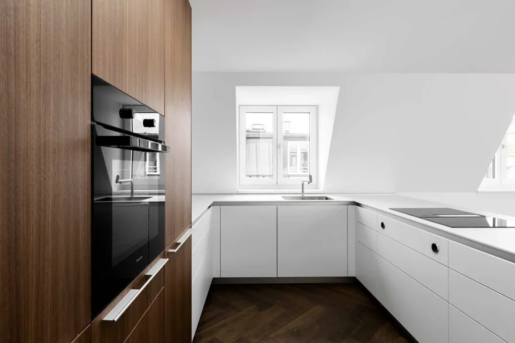 Moderne Einbauküche mit weißen Schränken und Holzverkleidung