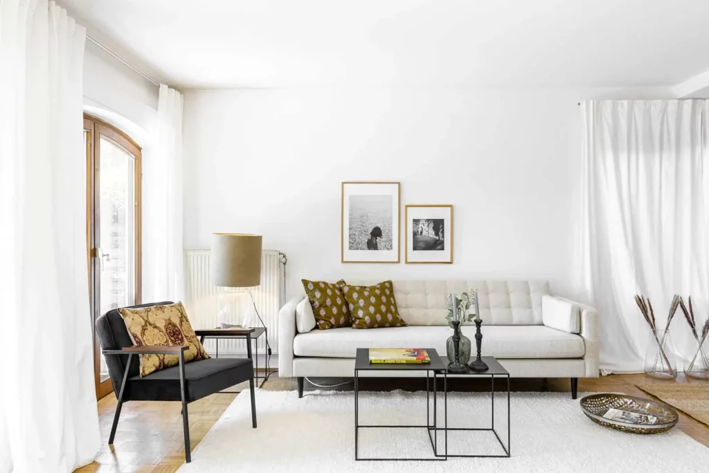 Modernes Wohnzimmer mit cremefarbenem Sofa und dekorativen Kissen