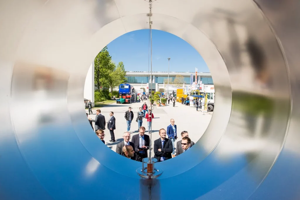 Industrieausstellung im Freien mit Besuchern und großen Maschinen