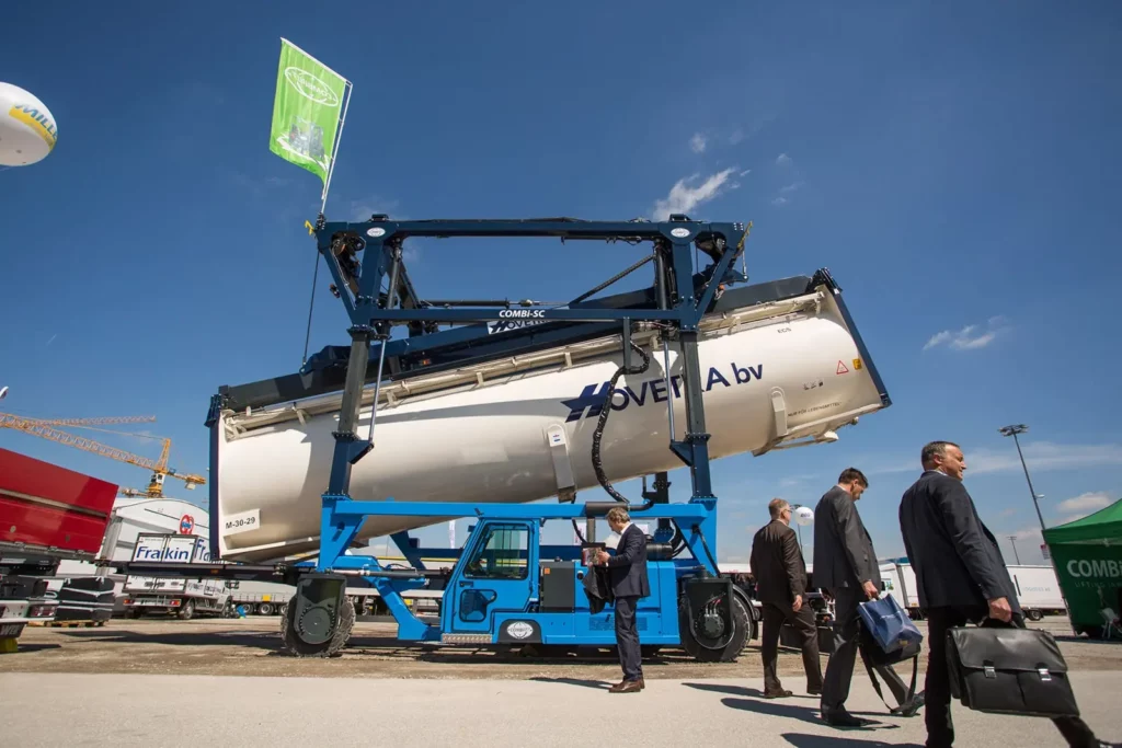 Messebesucher betrachten große Transportmaschine bei Außenveranstaltung