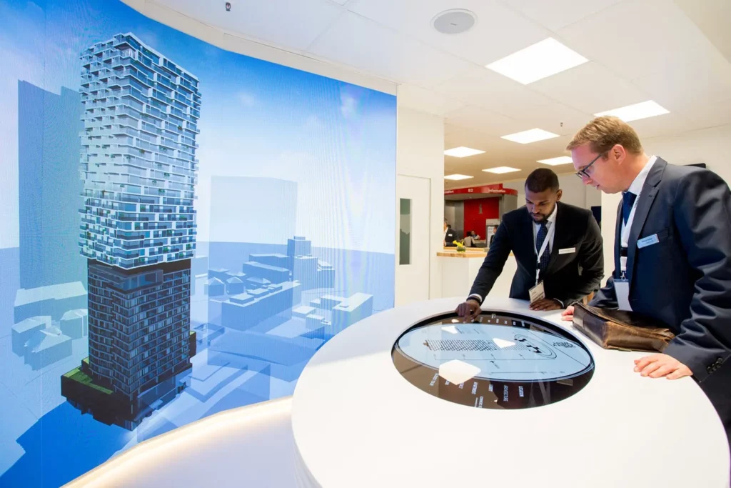 Zwei Männer betrachten interaktives städtebauliches Modell in modernem Büro