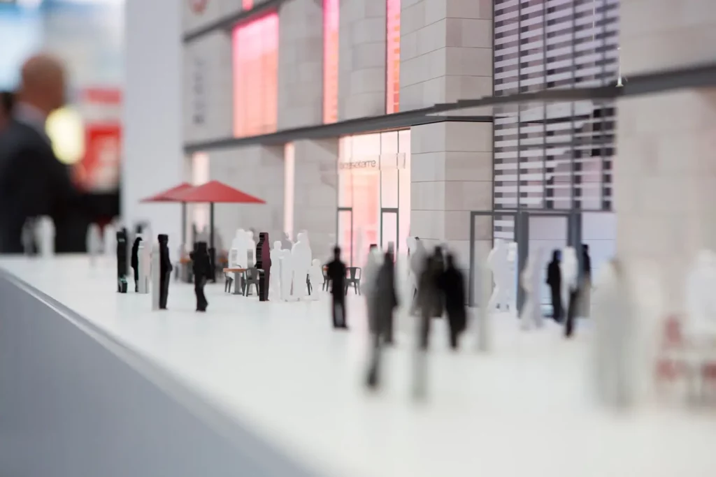 Architekturmodell eines modernen Gebäudes mit Menschenfiguren