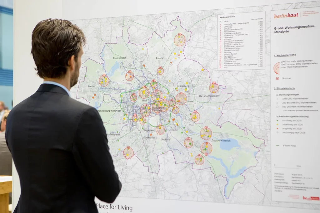Mann analysiert Karte mit Wohnungsbauprojekten in Berlin