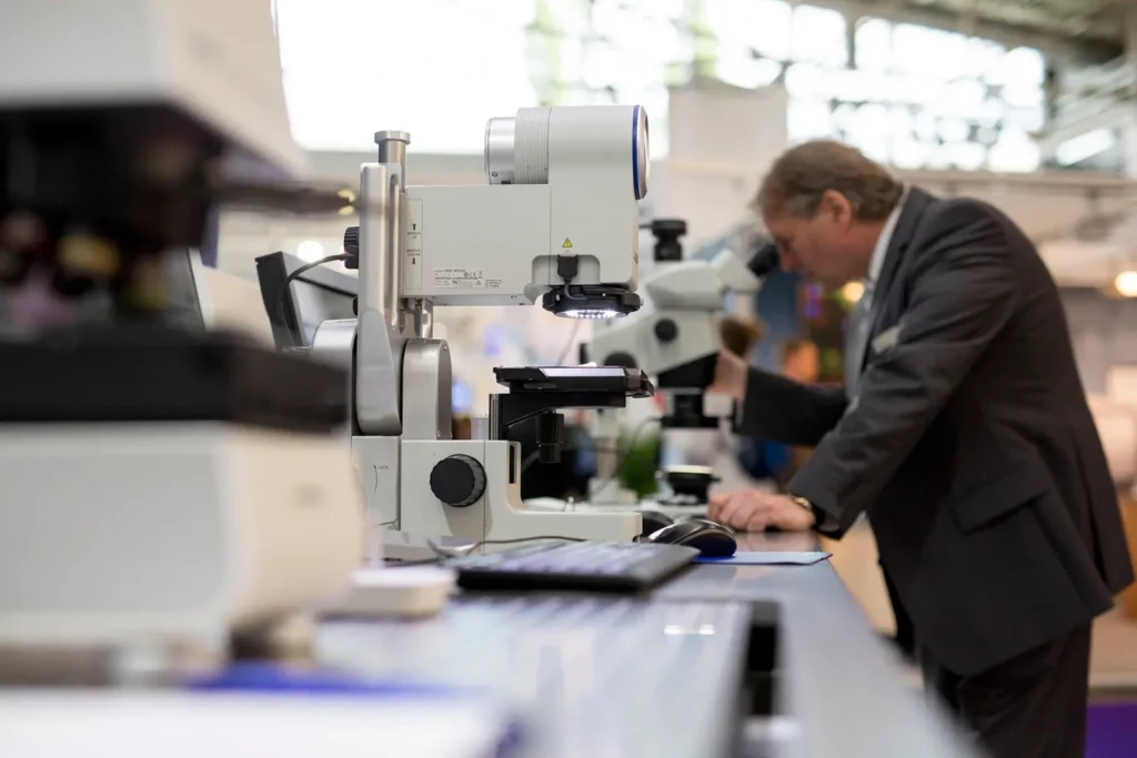 Forscher mit Mikroskop auf wissenschaftlicher Konferenz