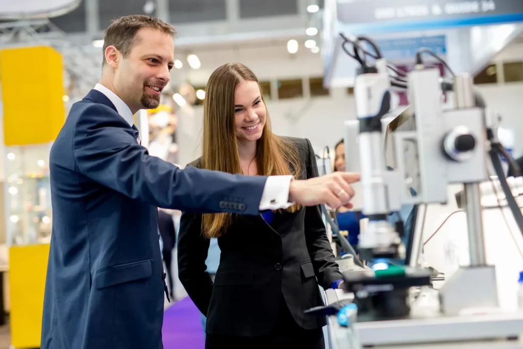 Geschäftsleute bei einer technischen Messe oder Ausstellung, die Geräte inspizieren