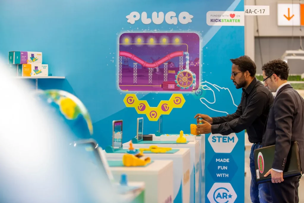 Männer auf einer Messe interagieren mit einem STEM-Spielestand