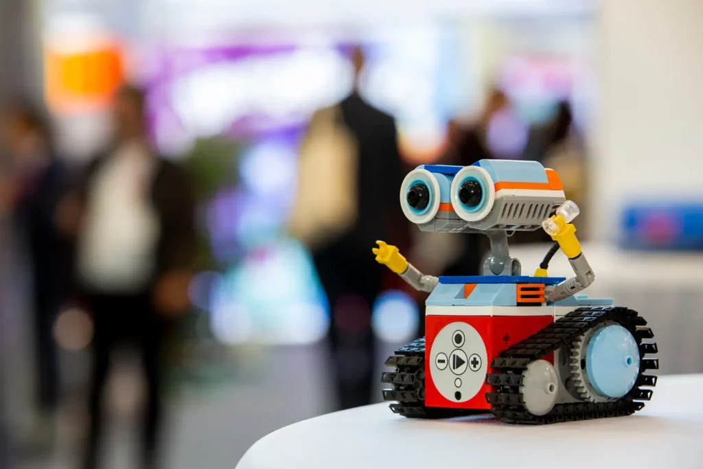 Kleiner bunter Roboter auf einem Tisch bei einer Messe