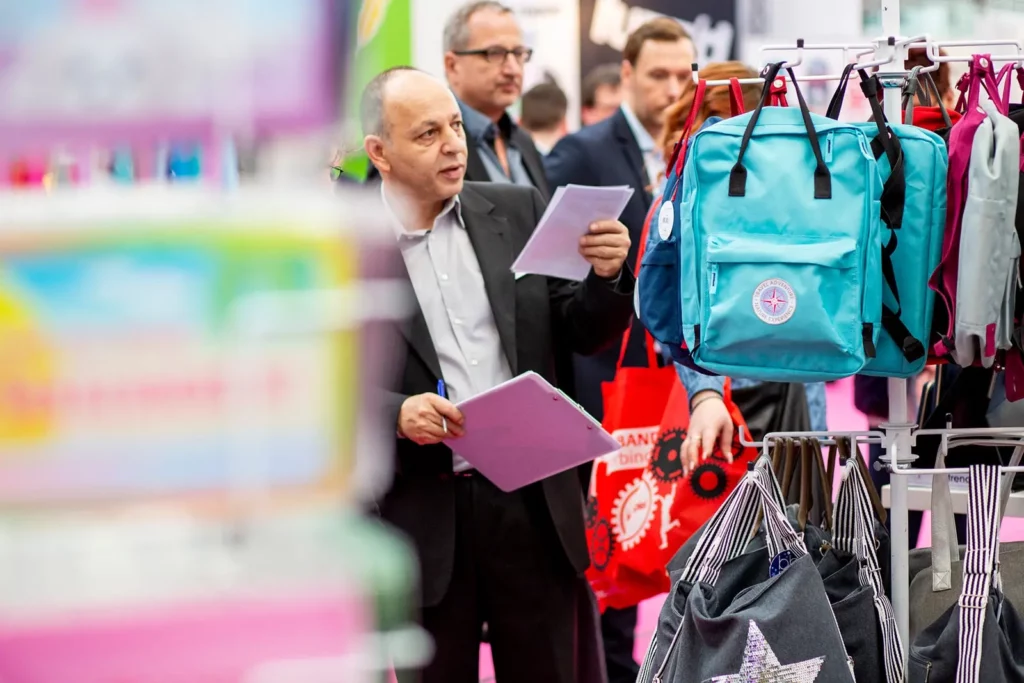 Messebesucher betrachten Rucksäcke auf einer Verkaufsveranstaltung