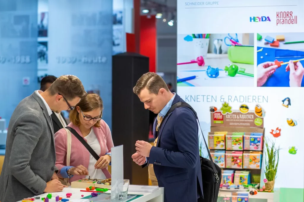 Menschen begutachten Schreibwaren auf einer Messe