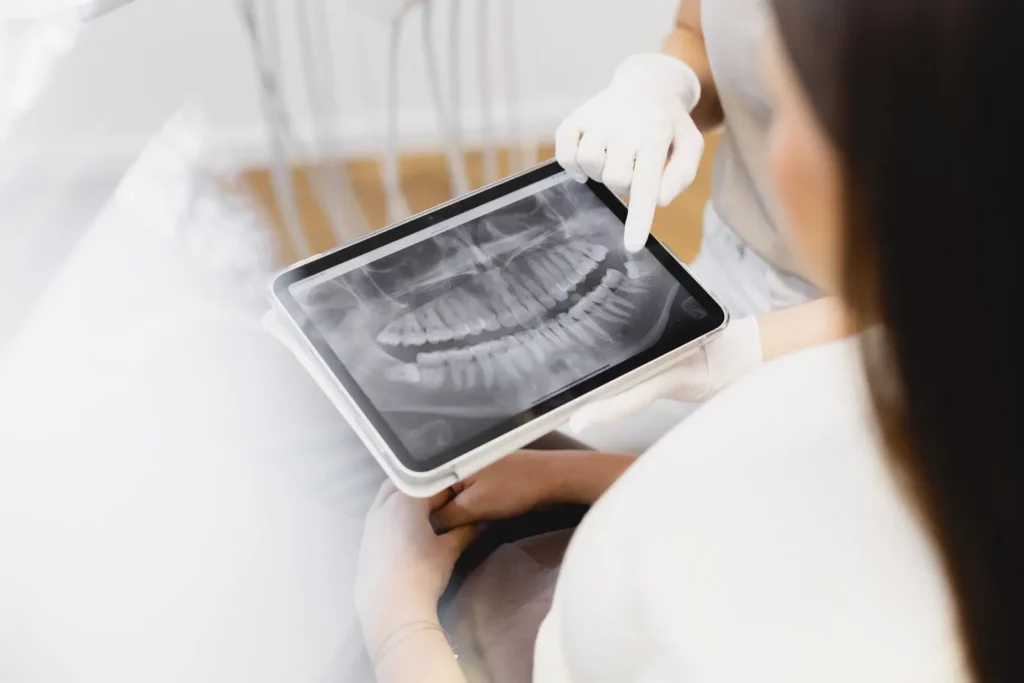 Zahnarzt zeigt Röntgenbild eines Gebisses auf Tablet