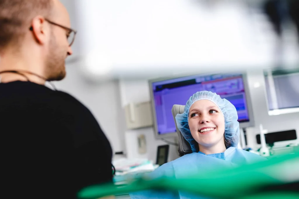 Zahnärztegespräch mit entspannter Patientin im Behandlungszimmer