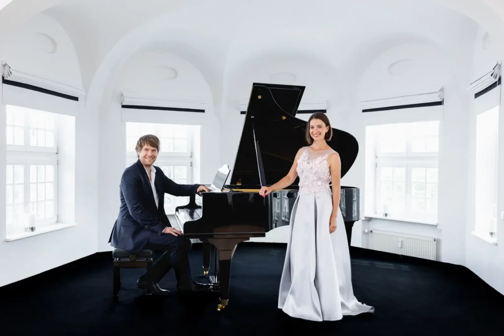 Elegantes Paar mit Flügel in stilvollem weißem Raum