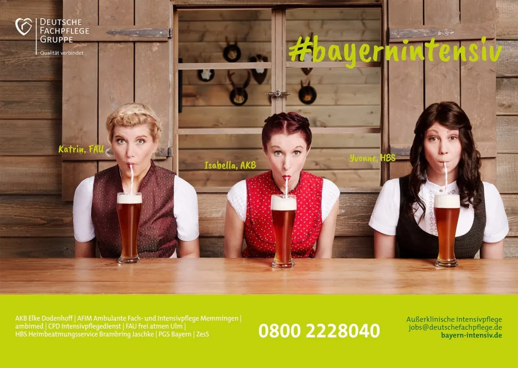 Drei Frauen in Tracht trinken Bier aus Strohhalmen