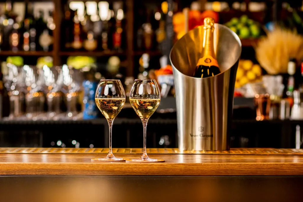 Zwei Gläser Champagner in einer Bar mit Flasche im Hintergrund